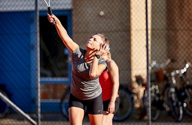 Kvinde i gang med at serve ude.jpg