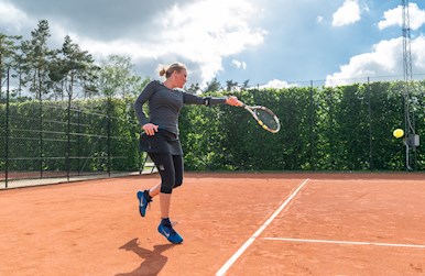 Kvinde slår forhånd udendørs.jpg