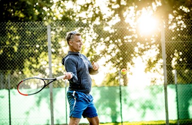 Mand i solskin spiller med orange bold.jpg