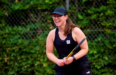 Ung kvinde smiler til tennis