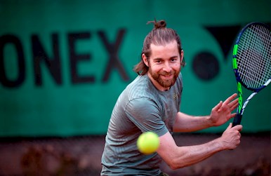 Ung mand slår tennisslice