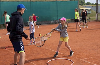 Pige spiller tennis med voksen.jpg