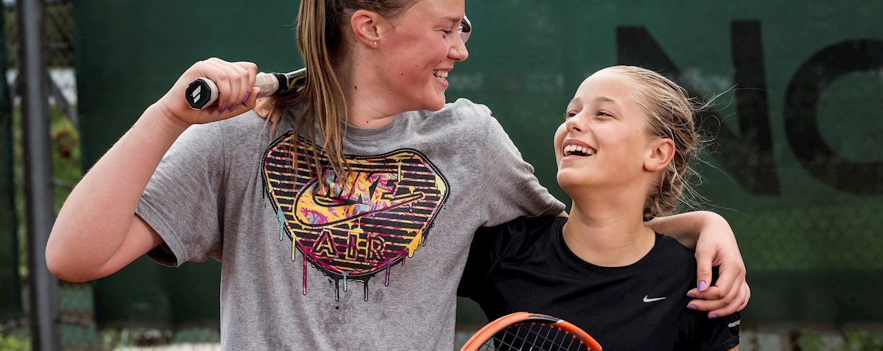 Kvinde og pige griner efter tenniskamp