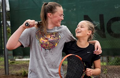 Kvinde og pige griner efter tenniskamp