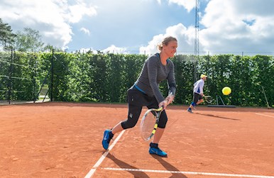 Tenniskvinde slår dobbeltbaghånd.jpg