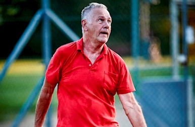 Ældre mand i gang med tennisserv.jpg