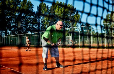 Tennismand står bag net.jpg